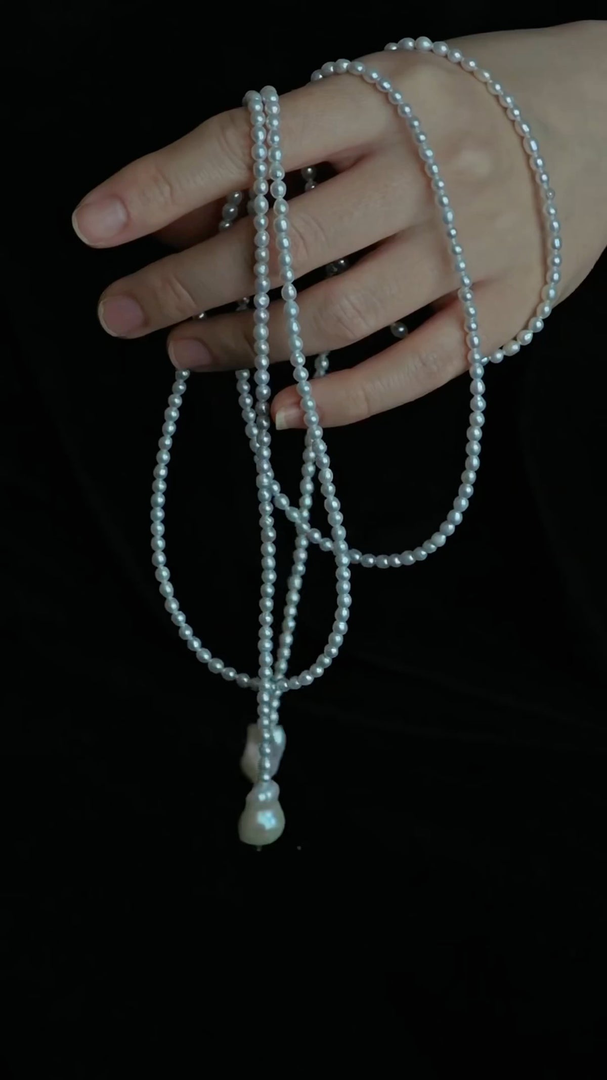 Pearl necklace draped over a hand