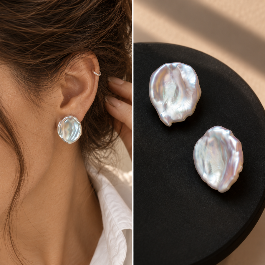 Irregular pearl earrings shown worn and as a pair in warm light.